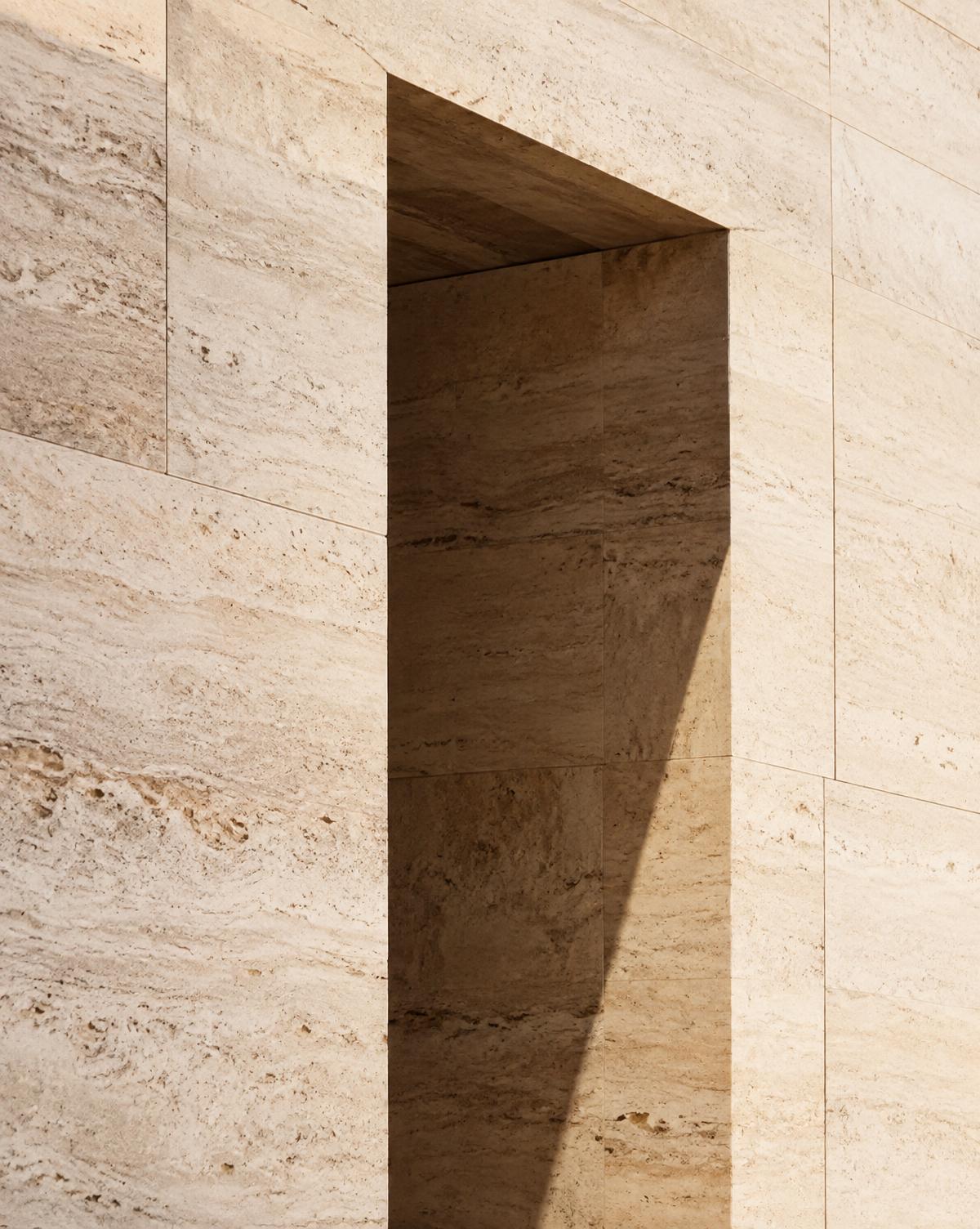 Sunlit travertine wall with a deep rectangular opening